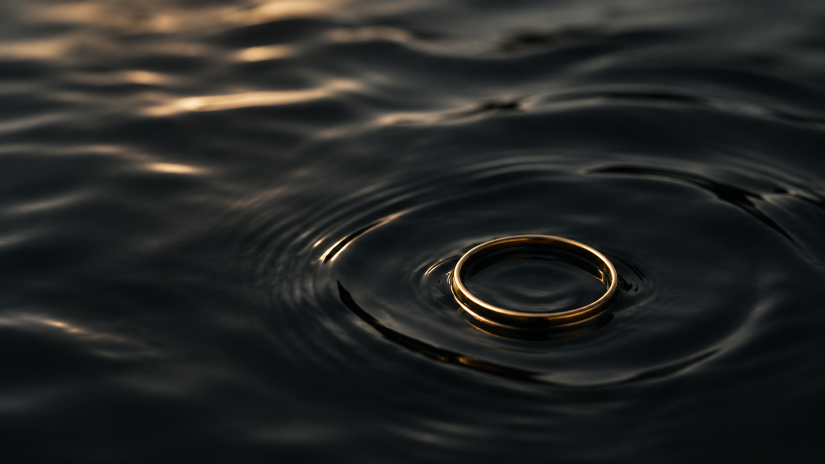 A golden ring resting on dark water.